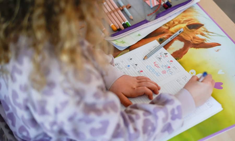 Schülerin schreibt in ihr Klassenheft
